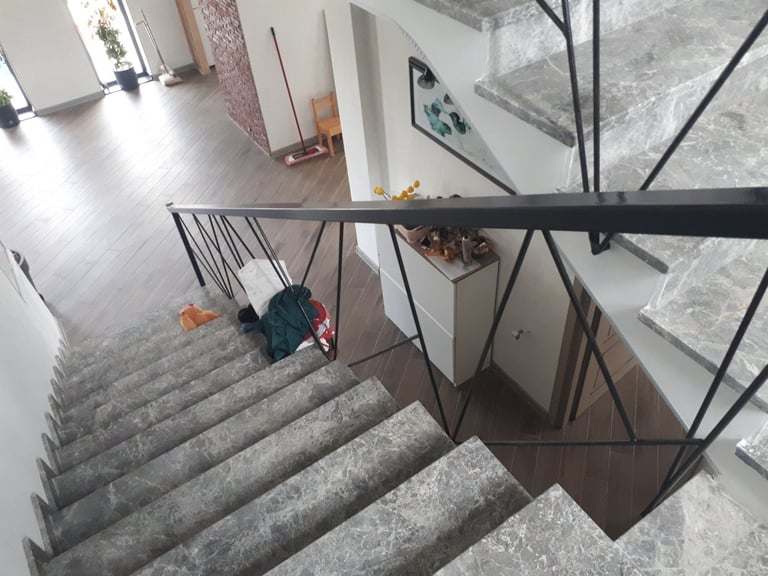 Overhead view of concrete staircase with black metal handrail in industrial loft space